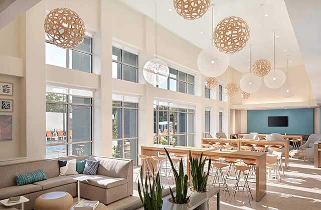 lobby with vaulted windows atrium globe lights tables and sofas at element orlando international drive