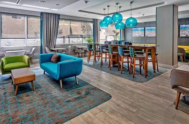 lounge area with blue and green seating and globe lights at hampton inn miami beach mid beach