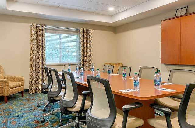 meeting room with a long table deluxe office chairs and cabinets at candlewood suites fort myers sanibel gateway