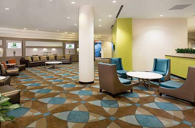 modern lounge lobby area with large column in green brown and blue at holiday inn palm beach airport conference center
