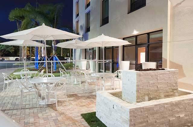 outdoor patio seating with stone fountain at night at delta hotels orlando lake buena vista
