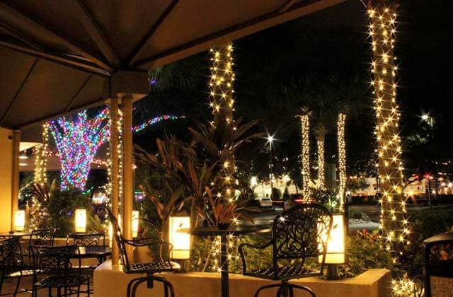 patio at night with holiday lights on trees at rosen inn at pointe orlando