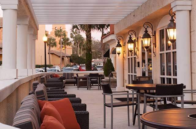patio with outdoor seating pergola with columns and lantern lighting at towneplace suites the villages