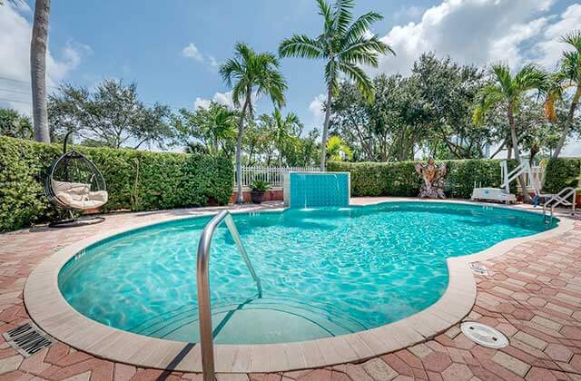 pool area with waterfall feature at best western plus palm beach gardens hotel and suites conference center