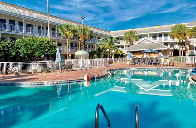 pool area with bar and blue umbrellas at clarion suites maingate