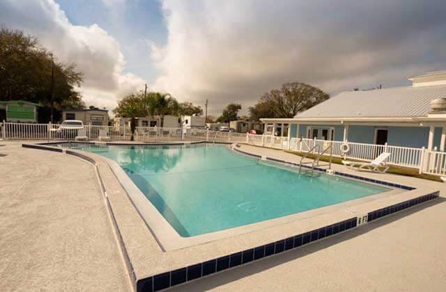 pool area with blue clubhouse at sun outdoors orlando championsgate rv resort