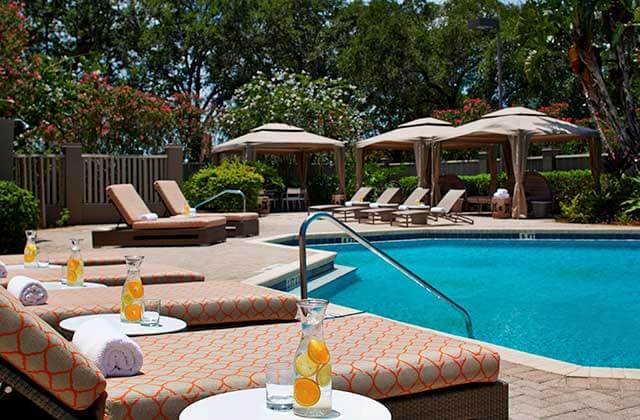 pool area with brown and orange lounge chairs at renaissance orlando airport hotel