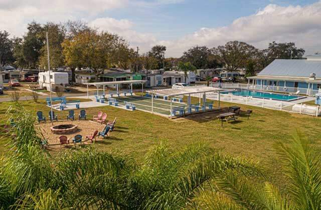 pool area with fire pit chairs and shuffleboard courts at sun outdoors orlando championsgate rv resort