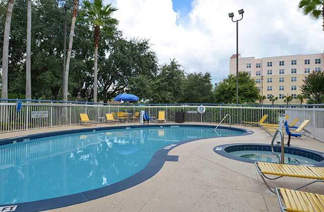 pool area with hot tub and yellow chairs at fairfield inn orlando airport