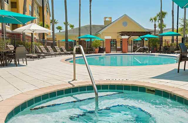 pool area with jacuzzi and teal umbrellas at homewood suites by hilton orlando ucf area