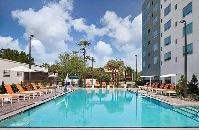 pool area with orange lounge chairs at aloft orlando international drive