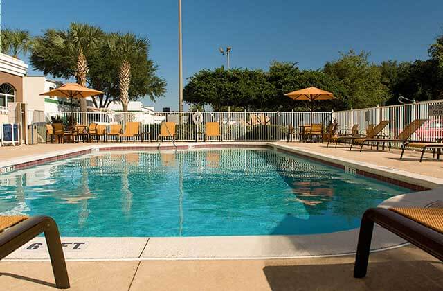 pool area with orange lounge chairs and umbrellas at fairfield inn and suites orlando lake buena vista
