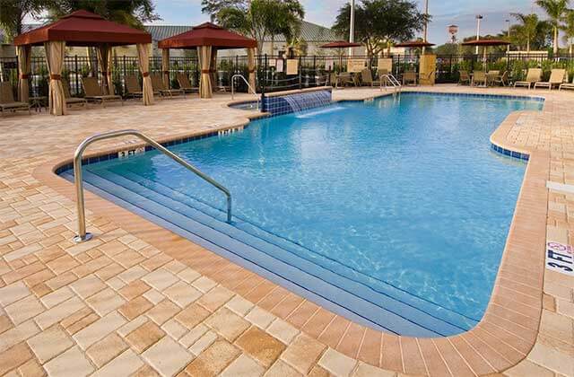 pool area with waterfall feature and maroon cabanas at hampton inn suites sarasota lakewood ranch