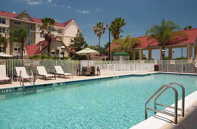 pool area with white lounge chairs and kids splash area at springhill suites orlando convention center international drive area