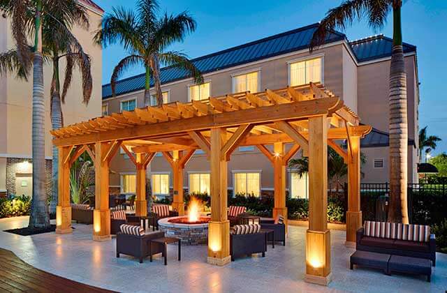 red wood pergola with patio seating and fire pit at courtyard sarasota university park lakewood ranch area