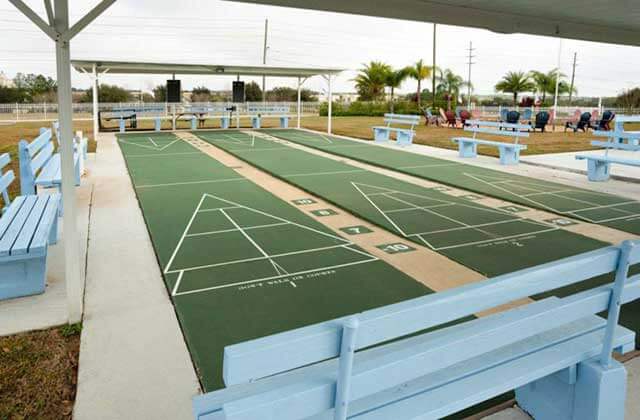 shuffleboard court with blue benches at sun outdoors orlando championsgate rv resort