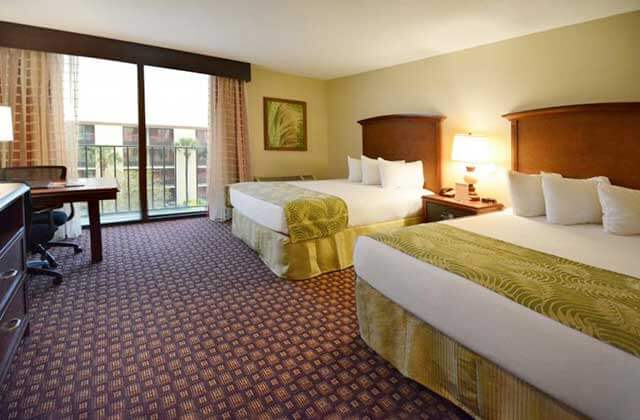 spacious hotel room with two large beds and balcony at rosen inn orlando