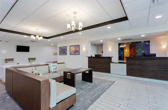 trendy lobby area with reception and sofas in white with dark wood decor at wyndham garden tallahassee capitol