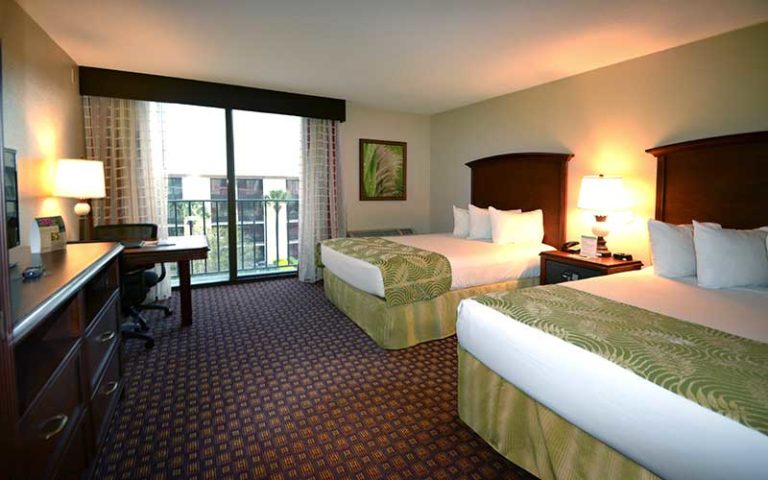 two king bed hotel room with balcony view at rosen inn