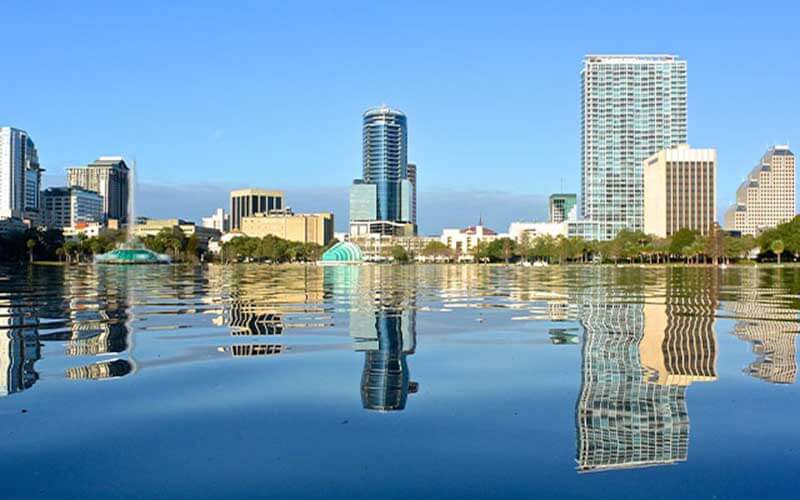 photo of lake eola surrounded by city buildings