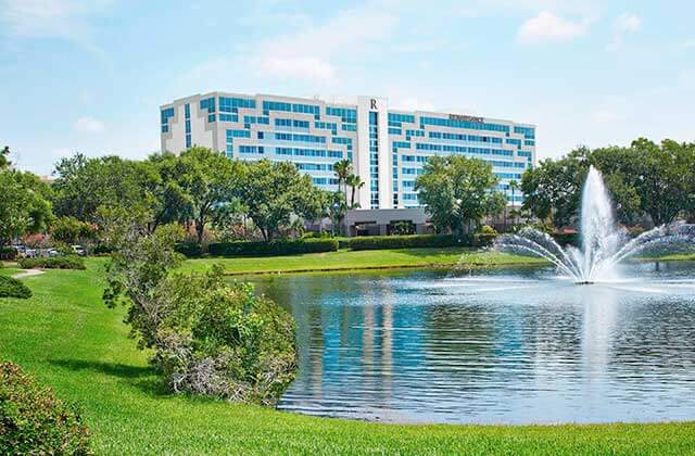 view across water of exterior of high rise hotel with fountain at renaissance orlando airport hotel