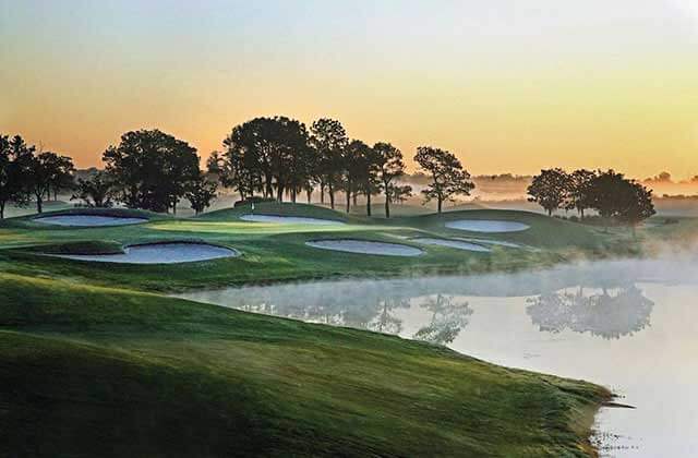 golf green with sand bunkers lake with fog and sunrise at falcons fire golf club kissimmee