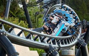riders hold on tight as a blue roller coaster swirls on jurassic world veloci-coaster at islands of adventure universal orlando resort