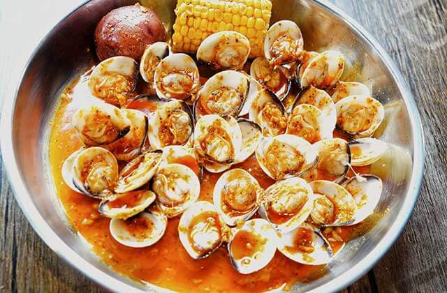 seafood boil bowl with seasoned clams cob corn and potatoes at the juicy crab orlando