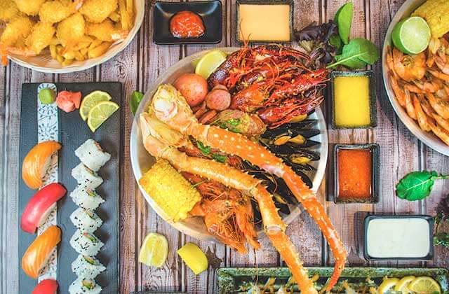 several sushi and seafood menu items arranged on a wood table at crack n roll restaurant kissimmee