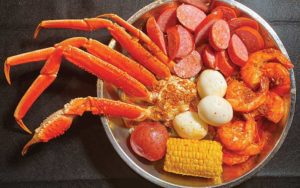 steel plate seafood boil with crab legs sausage corn cob eggs and shrimp at the juicy crab international drive orlando