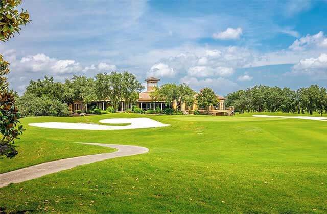 view of clubhouse across 18th hole with cart path and sand bunker at falcons fire golf club kissimmee