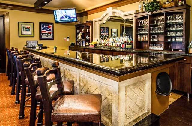 wood and marble bar with liquor bottles and stemware at falcons fire golf club kissimmee