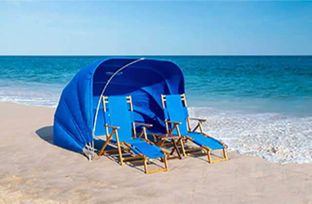 pair of blue lounge chairs with collapsible cabana on beach with blue water and clear sky at delray beaches