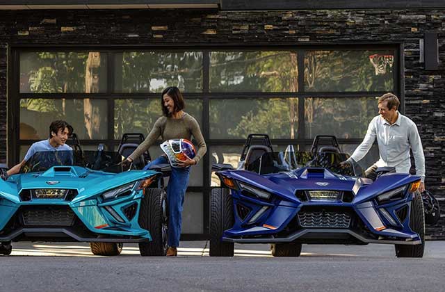 family climbing into two slingshot vehicles in front of garage of upscale home at florida slingshots