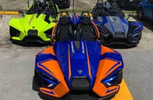 green gray orange and blue slingshot vehicles at florida slingshots