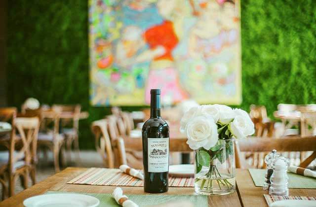 outdoor seating in dining area with flowers and bottle of wine at villaggio restaurant kissimmee