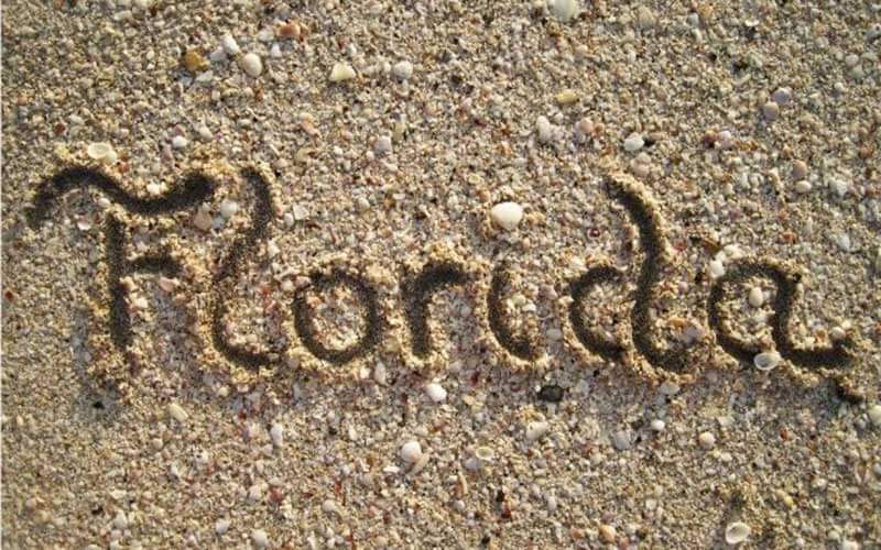 scripty word florida drawn in sand with shells at beach for fun in the winter sun blog