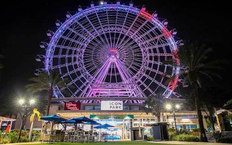 large ferris wheel at icon park orlando lit up with red white and blue led lights