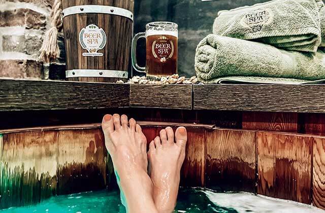 beer spa orlando crossed bare feet beer soak tub with mug of beer