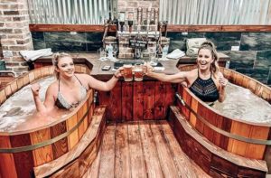 beer spa orlando side by side beer soak tubs with row of beer taps girls toasting