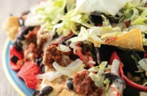 plate of beef nachos with lettuce, beans, cheese, and red and white chips at sloppy joes orlando restaurant at icon park orlando