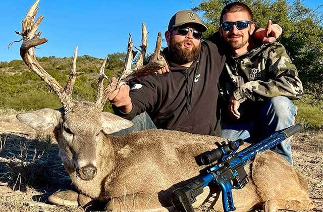two men with hunting apparel posing with whitetail deer and blue rifle for oxranch outfitters orlando kissimmee