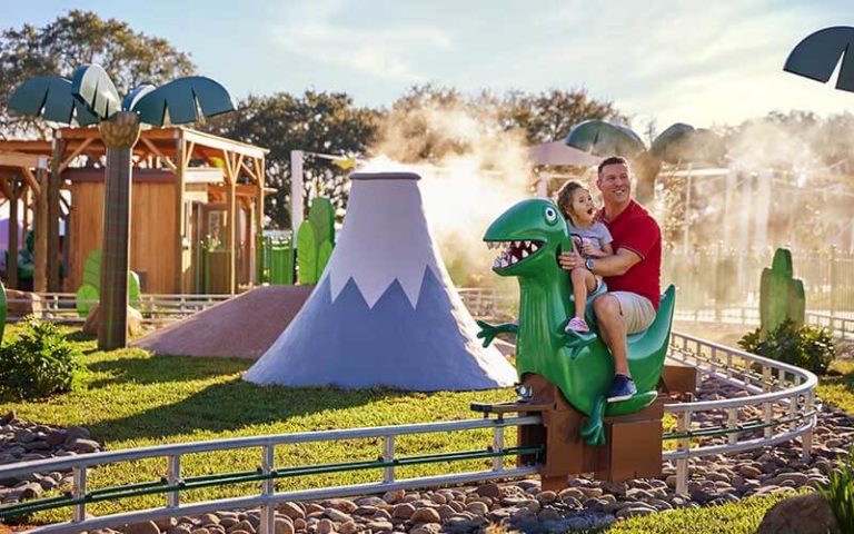 dad and daughter riding dinosaur ride at peppa pig theme park legoland florida