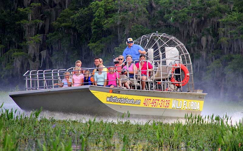 guided tour group on fanboat speeding across wetlands marsh for wild florida airboat blog