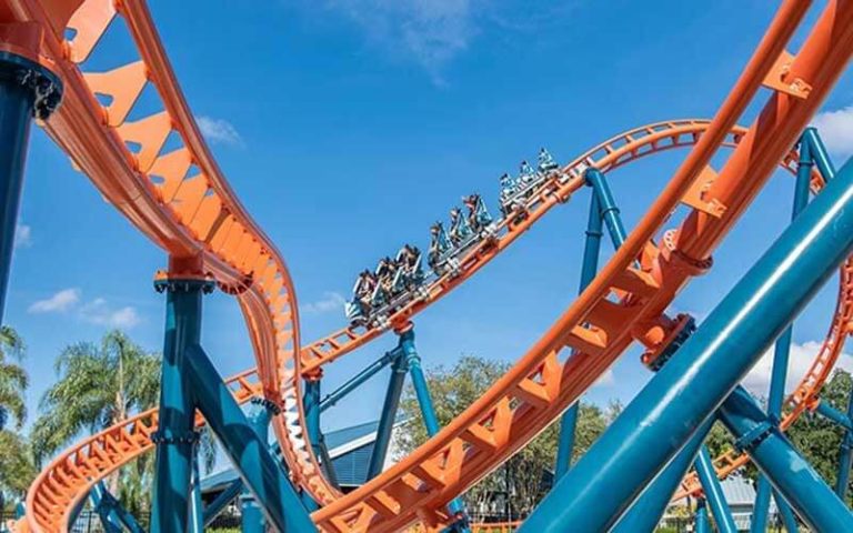 orange and blue coaster with looping rails and riders descending at seaworld on ice breaker ride