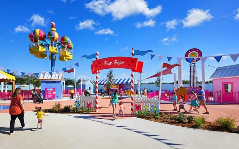 parents and kids entering fun fair area with rides at peppa pig theme park legoland florida