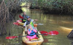 family in kayaks with dad pointing at wildlife at everglades florida adventures