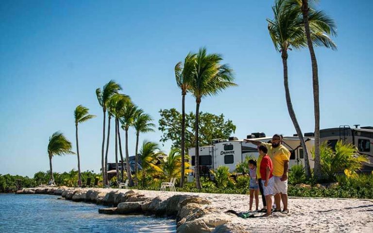 family walking along beach with rv campers at sugarloaf key key west koa holiday