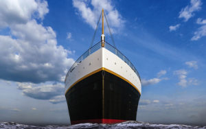 front facing hero shot of bow of titanic ship with waves and blue cloudy sky at titanic the artifact exhibition orlando