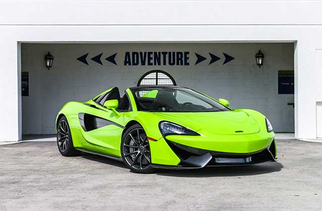 green mclaren supercar parked in front of building with word adventure at blast supercar driving experience